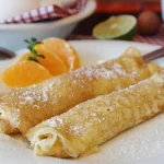 Crêpes posées dans une assiette avec quelques agrumes